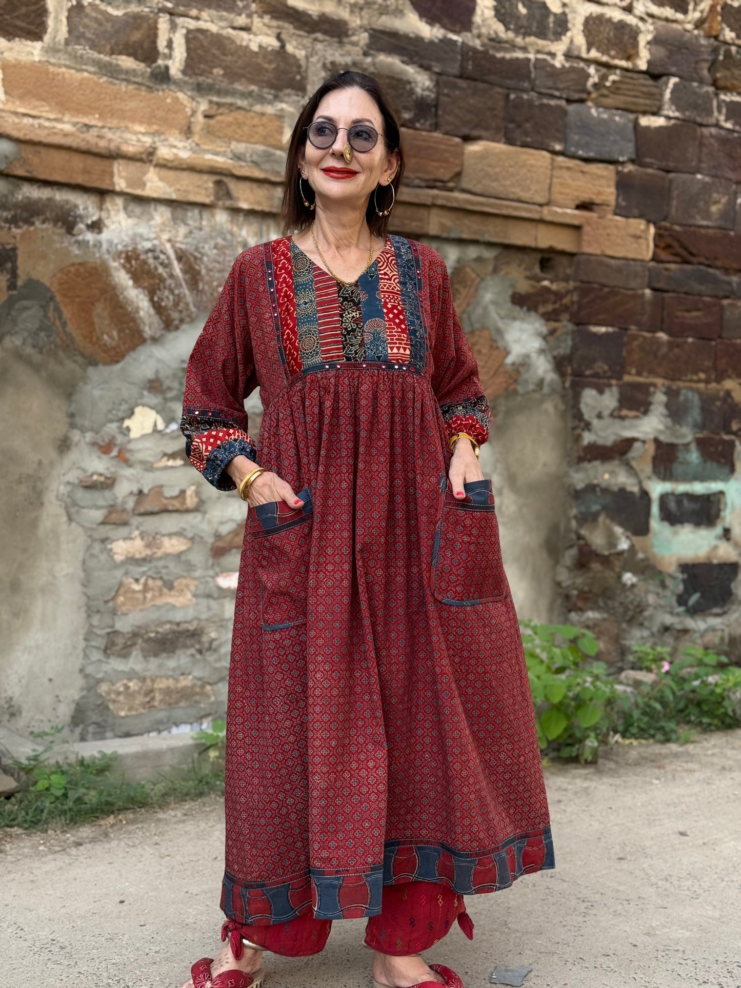 Red cotton dress from hand printed fabrics. A touch of hand embroidered mirrors highlights sleeve borders and bodice of mixed prints.