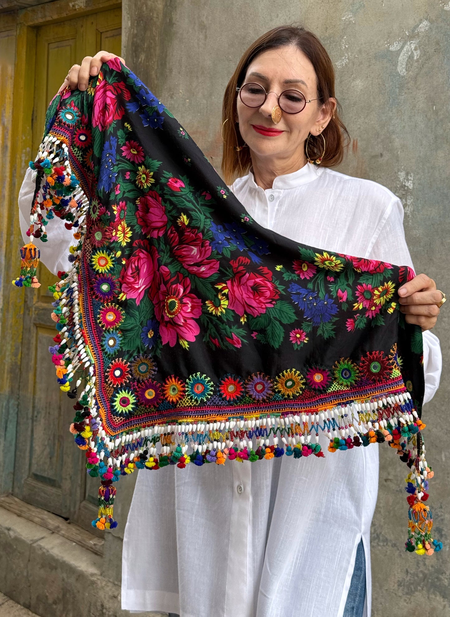 Black embroidered floral scarf with a fringe of colorful tassels and beadwork.