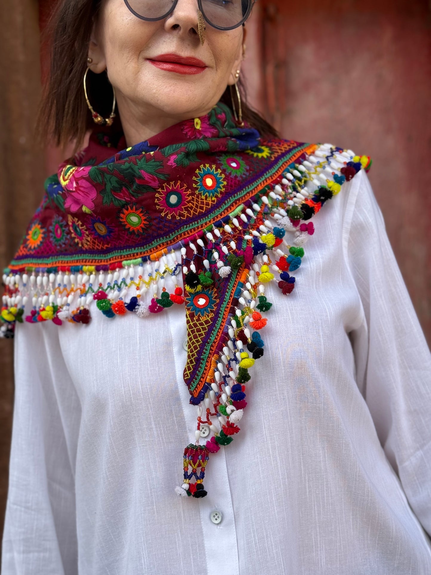 Red mirror embroidered scarf with a fringe of tassels and beadwork.