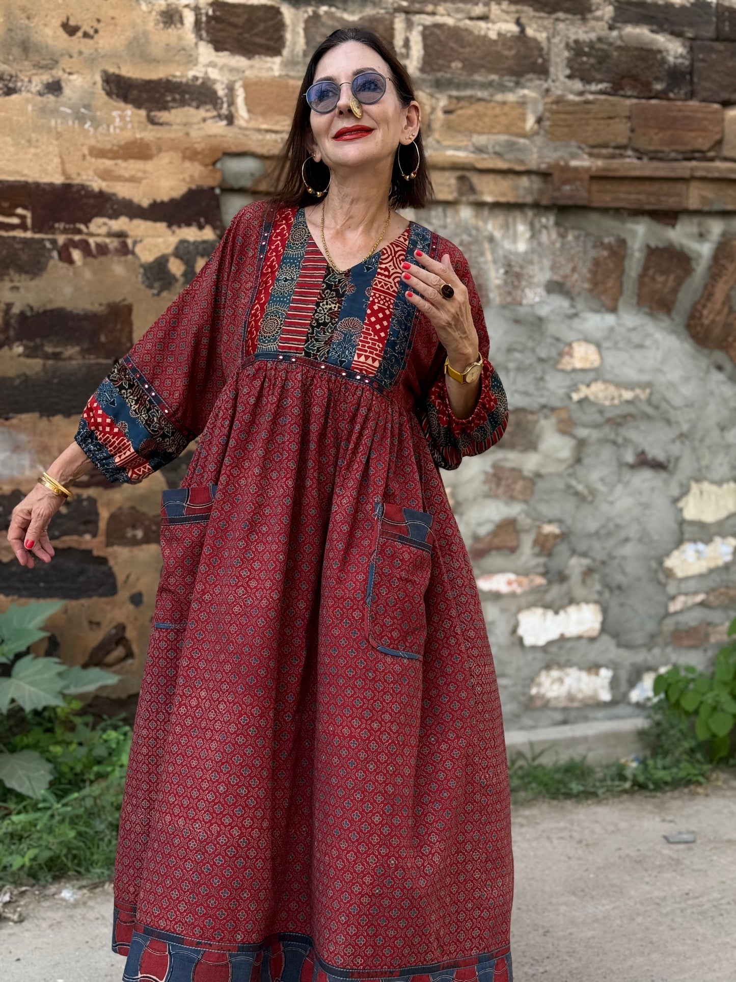 Red cotton dress from hand printed fabrics. A touch of hand embroidered mirrors highlights sleeve borders and bodice of mixed prints.