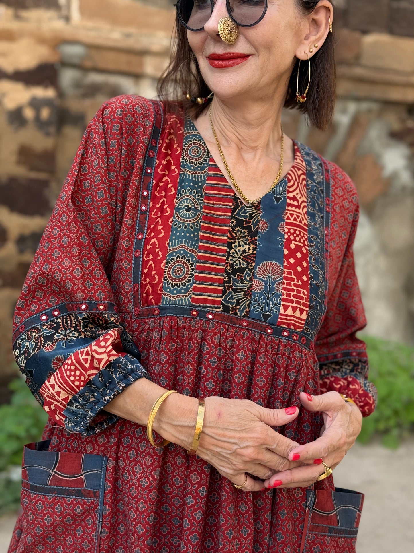 Red cotton dress from hand printed fabrics. A touch of hand embroidered mirrors highlights sleeve borders and bodice of mixed prints.