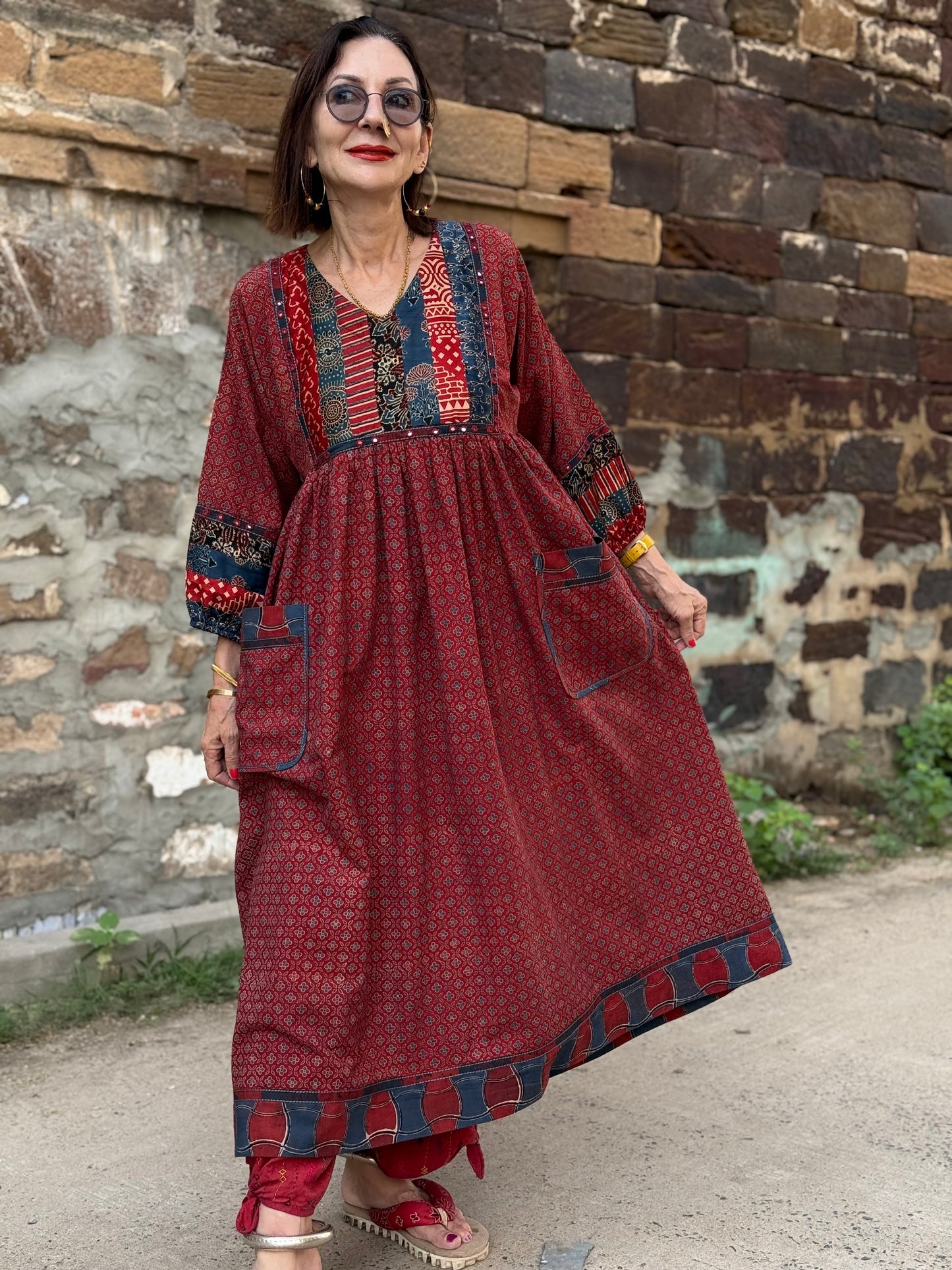 Red cotton dress from hand printed fabrics. A touch of hand embroidered mirrors highlights sleeve borders and bodice of mixed prints.
