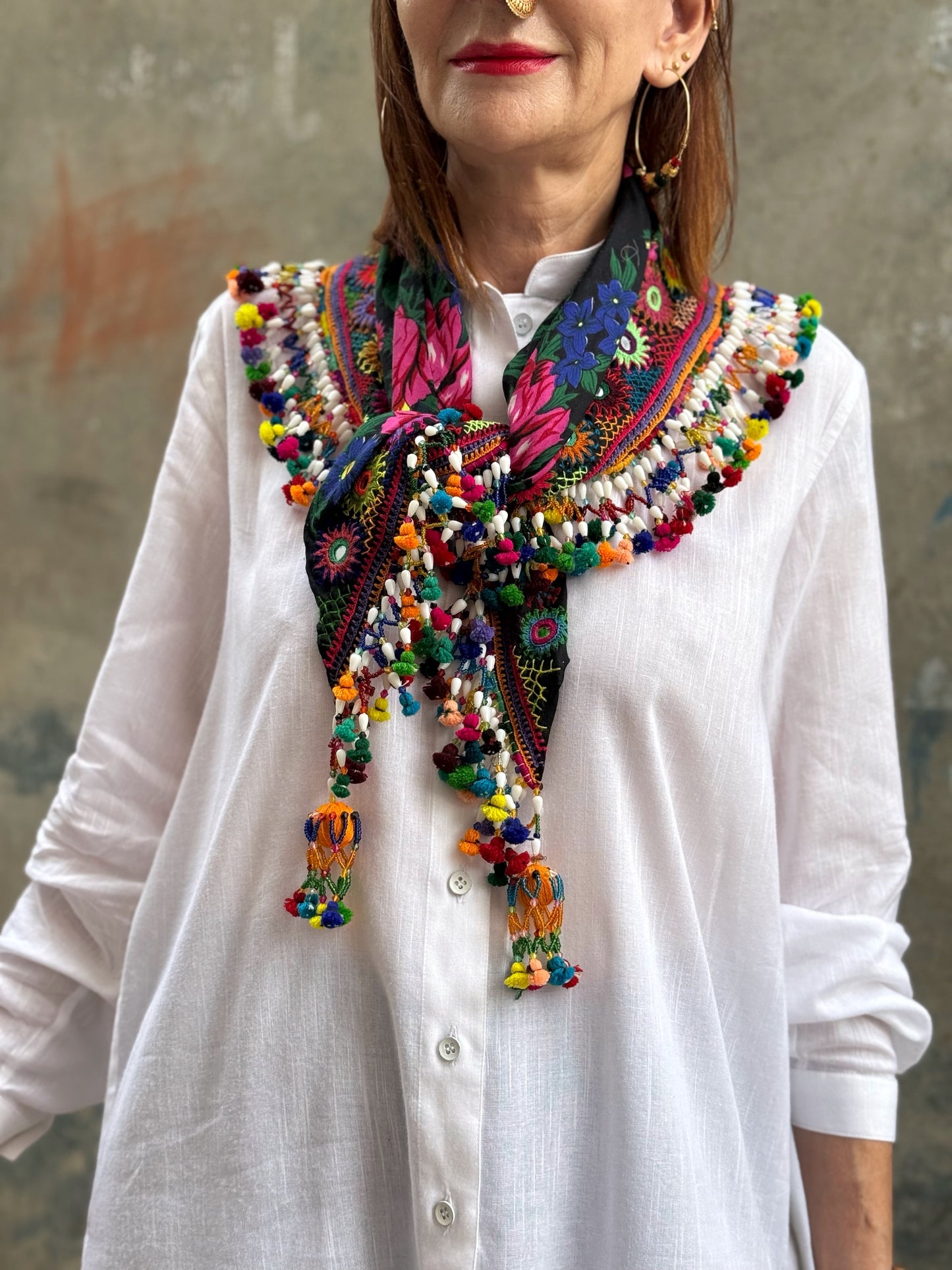 Black embroidered floral scarf with a fringe of colorful tassels and beadwork.