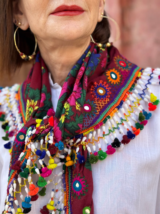 Red mirror embroidered scarf with a fringe of tassels and beadwork.