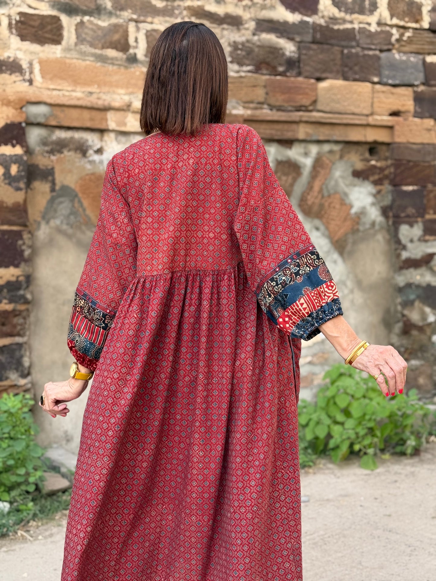 Red cotton dress from hand printed fabrics. A touch of hand embroidered mirrors highlights sleeve borders and bodice of mixed prints.