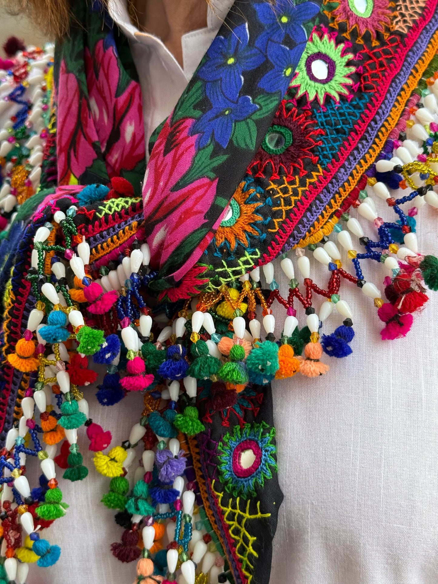 Black embroidered floral scarf with a fringe of colorful tassels and beadwork.