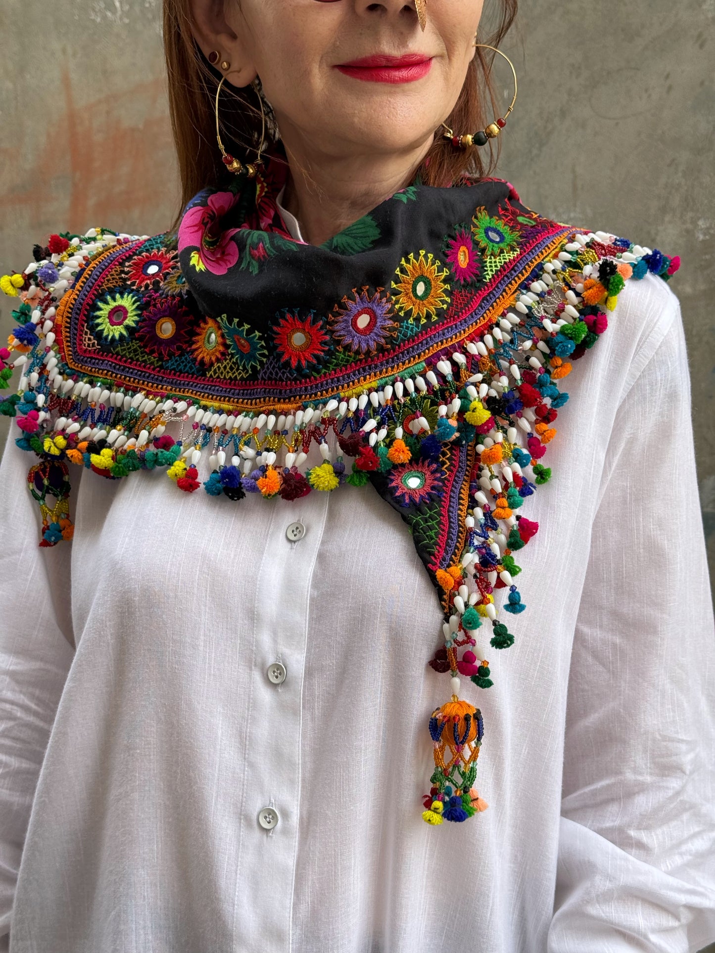 Black embroidered floral scarf with a fringe of colorful tassels and beadwork.