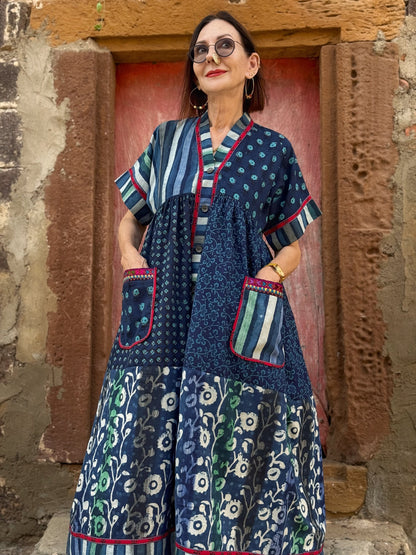 Button thru cotton dress in turquoise hues with red accents. All hand printed fabrics, this dress features vibrant Kutch hand embroidery.