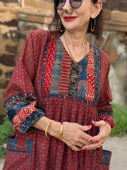 Red cotton dress from hand printed fabrics. A touch of hand embroidered mirrors highlights sleeve borders and bodice of mixed prints.