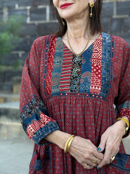 Red cotton dress from hand printed fabrics. A touch of hand embroidered mirrors highlights sleeve borders and bodice of mixed prints.